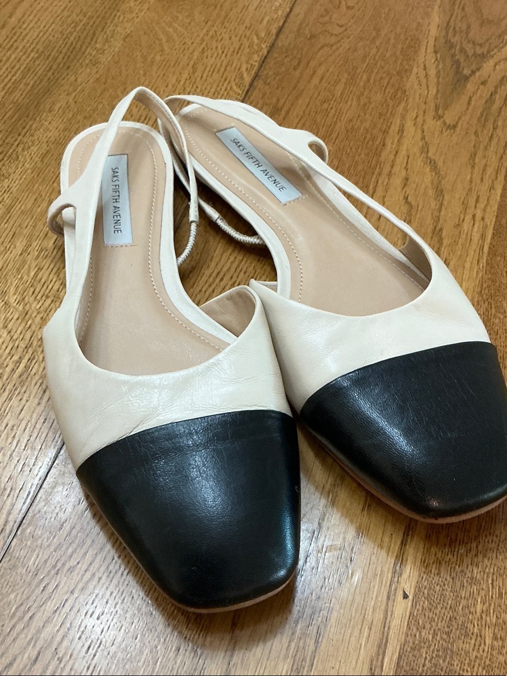 Woman’s Saks Fifth Avenue cream sling back shoes with black toe cap. Size 7.5.